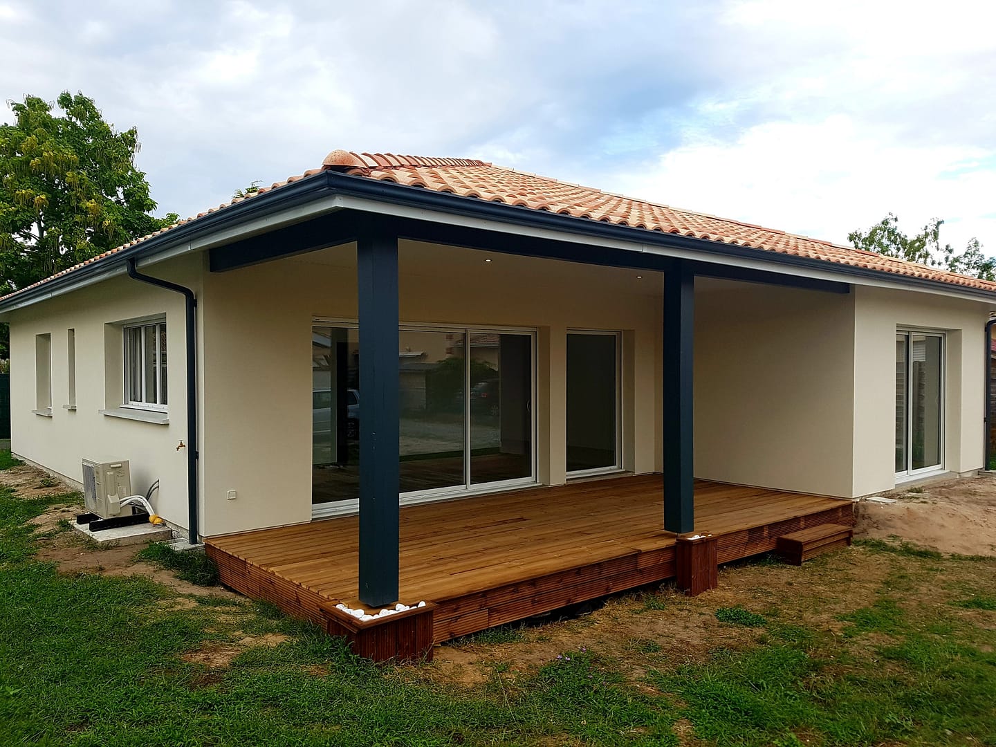 Maison moderne avec terrasse en bois et toiture tuiles